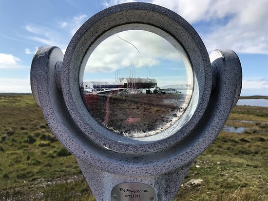 A photo of the Marconi Wireless Station's Powerhouse c. 1911 is projected onto the present landscape through a large circular mounted lens.